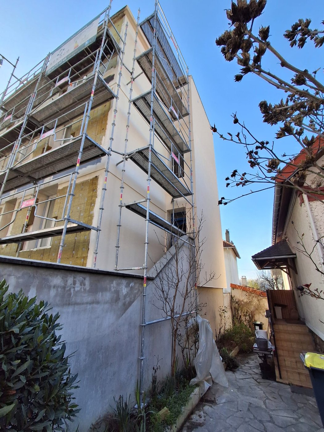 Façade latérale de la copropriété de Villemomble pendant l'application de l'enduit sur l'isolant