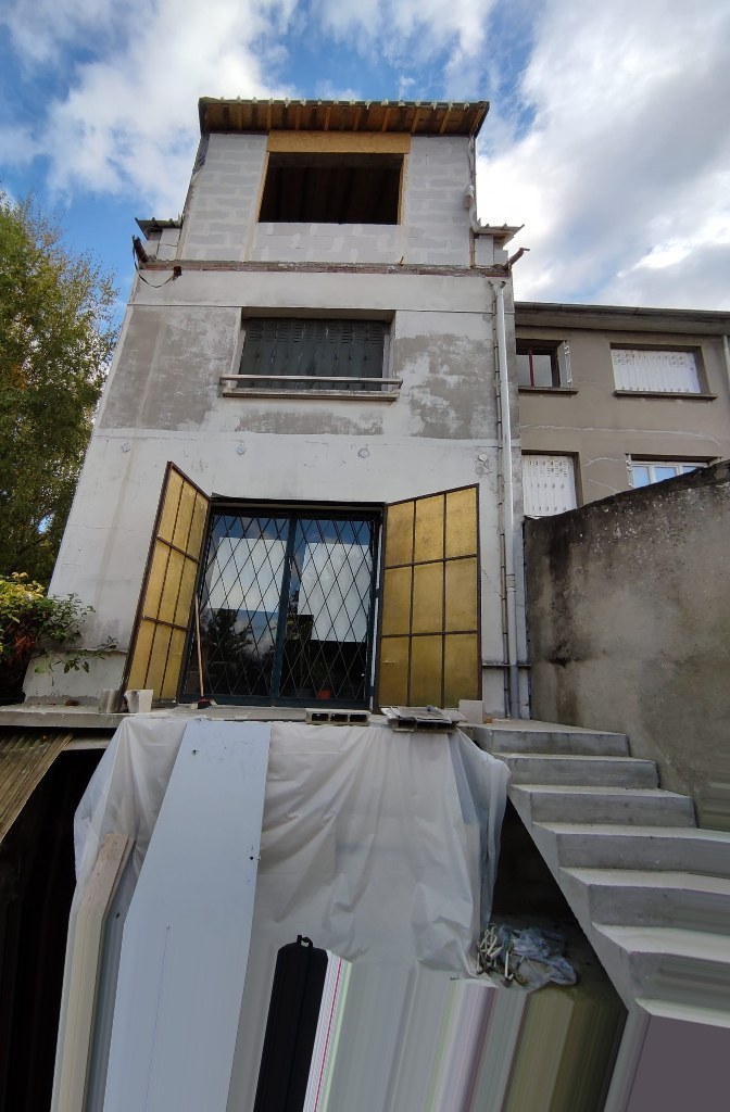 Façade côté jardin d'une maison à Bry-sur-Marne avant isolation par l'extérieur : enduit usé et extension en parpaings non enduite