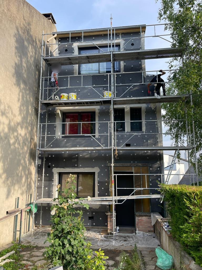 Façade d'entrée d'une maison à Bry-sur-Marne pendant la pose de l'isolant PSE 120 mm, équipe RENOCO sur l'échafaudage