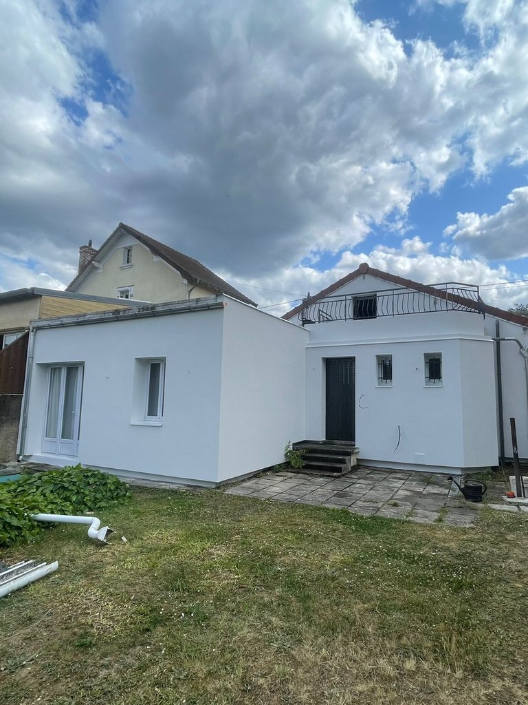 Maison à Champs-sur-Marne après isolation thermique par l'extérieur, façades côté jardin enduites en blanc