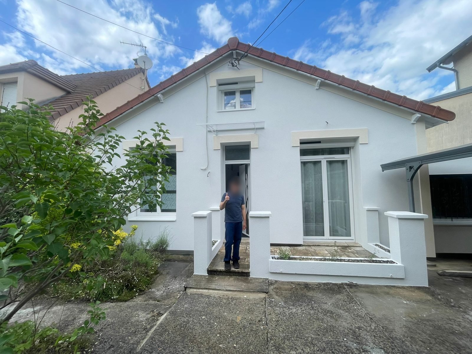 Maison à Champs-sur-Marne après isolation par l'extérieur, enduit blanc et linteaux reconstitués en teinte crème