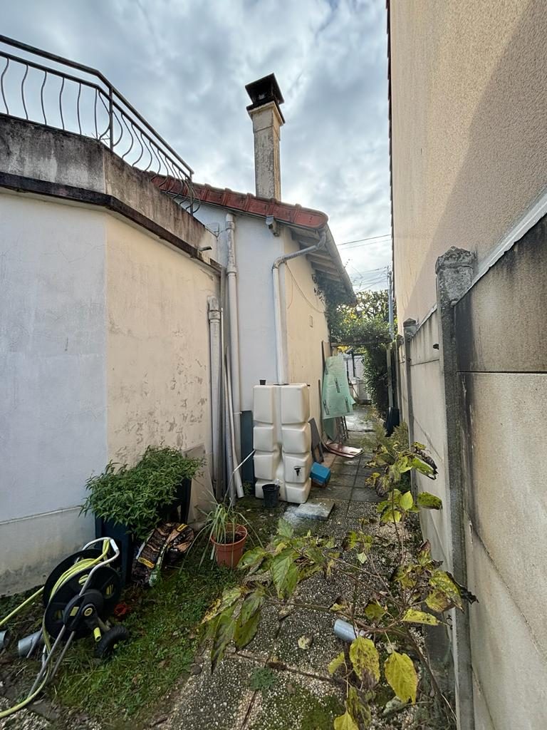 Passage étroit le long d'une façade à Champs-sur-Marne avant isolation par l'extérieur, enduit dégradé