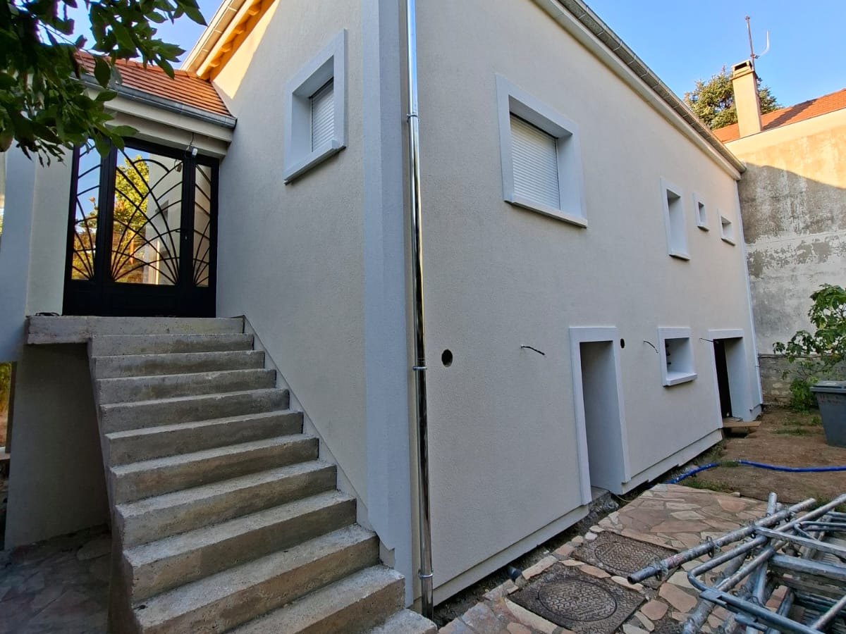 Maison à Créteil après isolation thermique par l'extérieur par Rénoco : façade droite et enduite, encadrements de fenêtres en relief