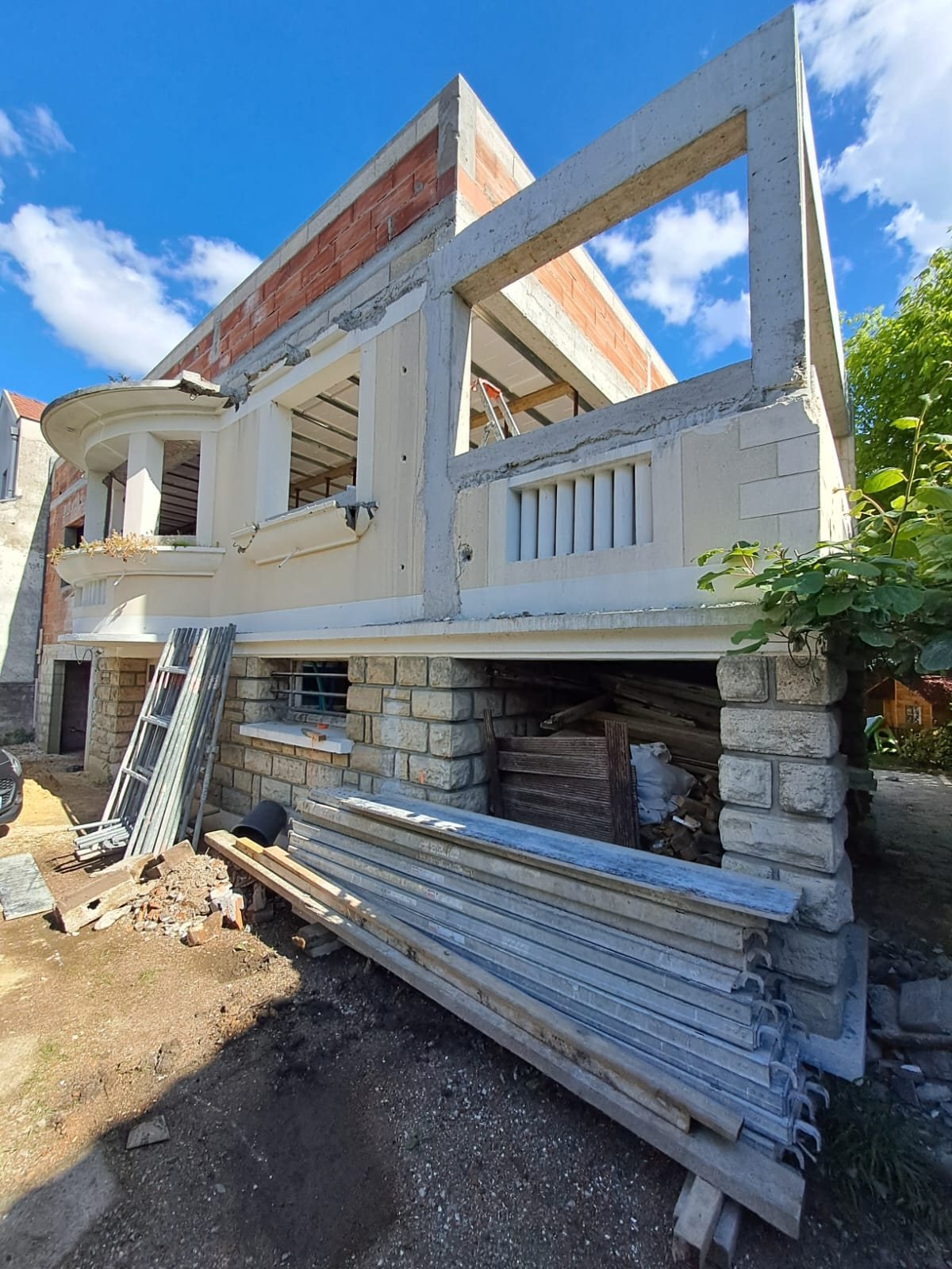 Maison à Créteil avant isolation par l'extérieur : extension en béton et brique, balcon arrondi, soubassement en pierre de taille décalé par rapport à l'étage
