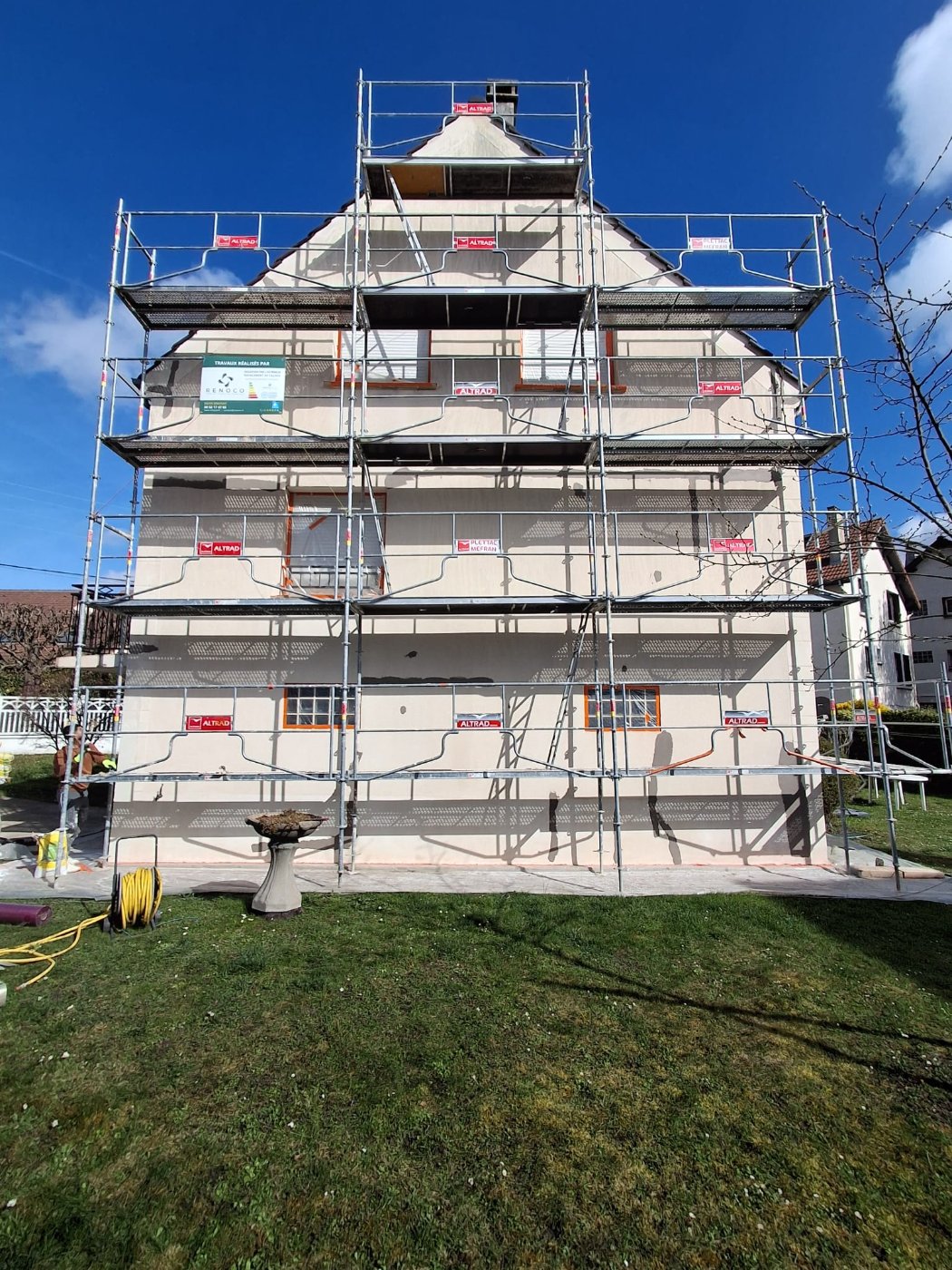 Échafaudage monté sur le pignon de la maison à Gournay-sur-Marne, fenêtres protégées par film et adhésif avant le ravalement