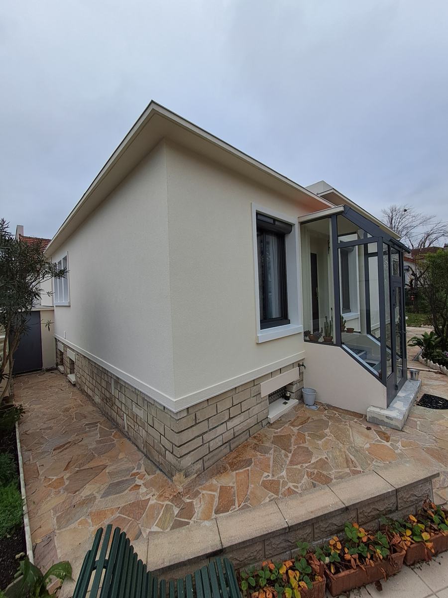 Pignon d'une maison à Maisons-Alfort après isolation par l'extérieur : soubassement en pierre conservé et ceinture reconstituée en PSE haute densité