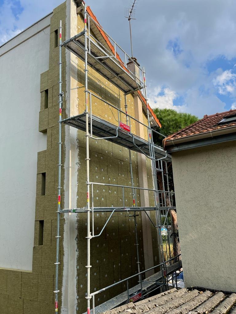 Isolation par l'extérieur du pignon d'une maison à Nogent-sur-Marne : panneaux de laine de roche 140 mm en cours de pose sous échafaudage