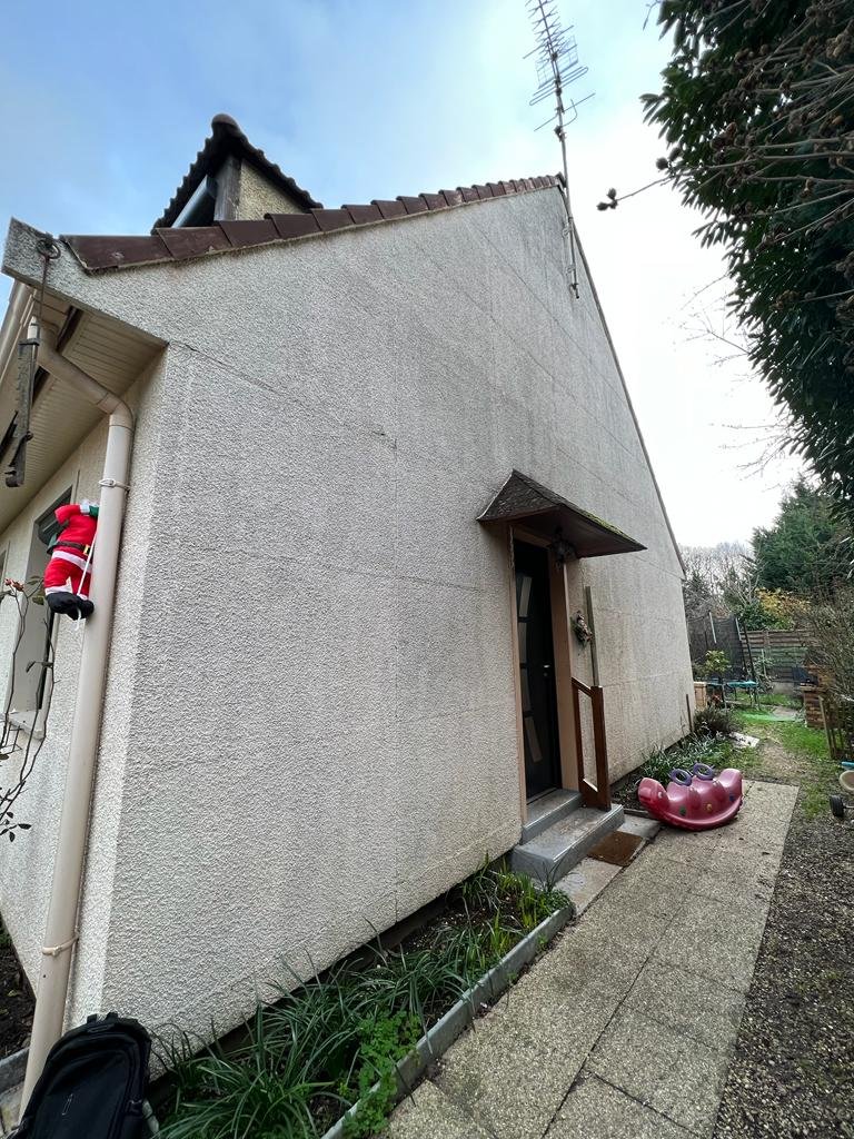 Pignon d'une maison Phénix : les jonctions des panneaux de béton préfabriqués se devinent sous l'enduit en lignes régulières