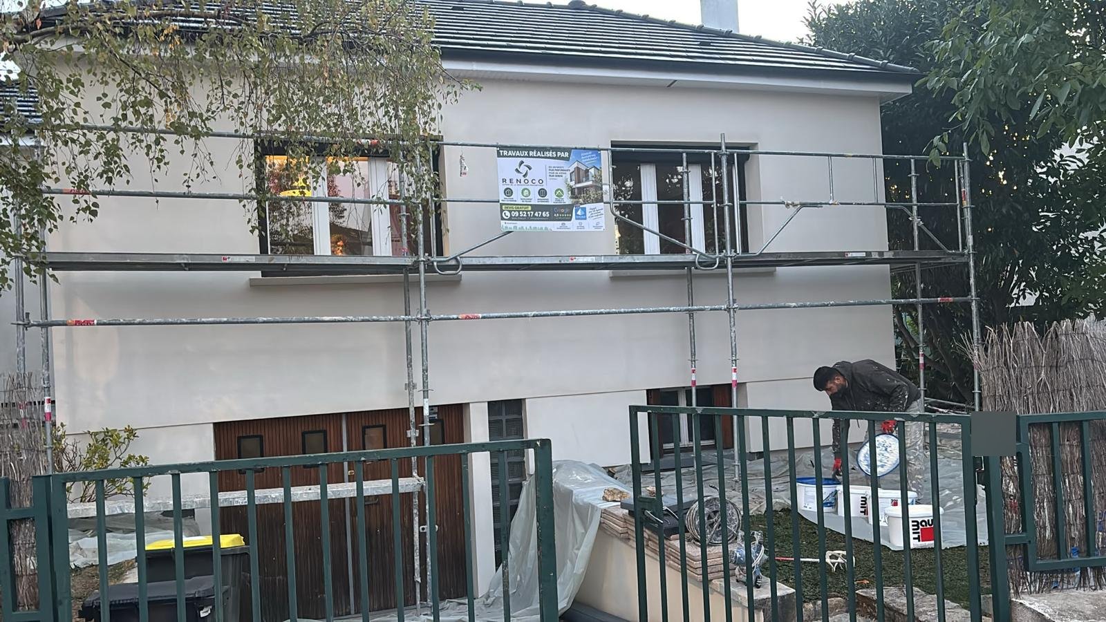 Façade d'un pavillon à Pontault-Combault après sous-enduit armé, compagnon Rénoco préparant l'enduit de finition Baumit