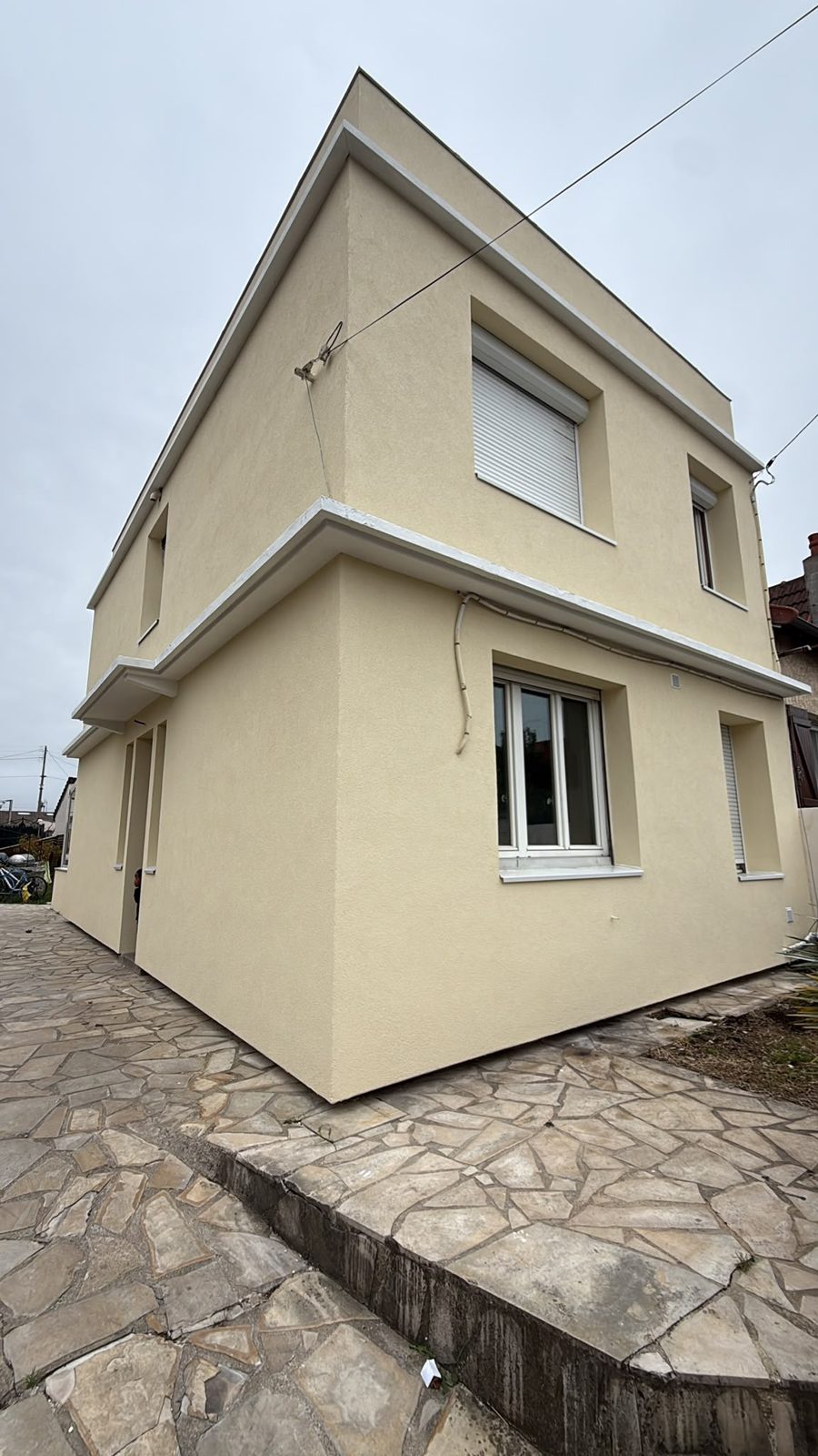Maison à Villeneuve-le-Roi après isolation thermique par l'extérieur en PSE 140 mm, bandeaux en béton repeints en blanc