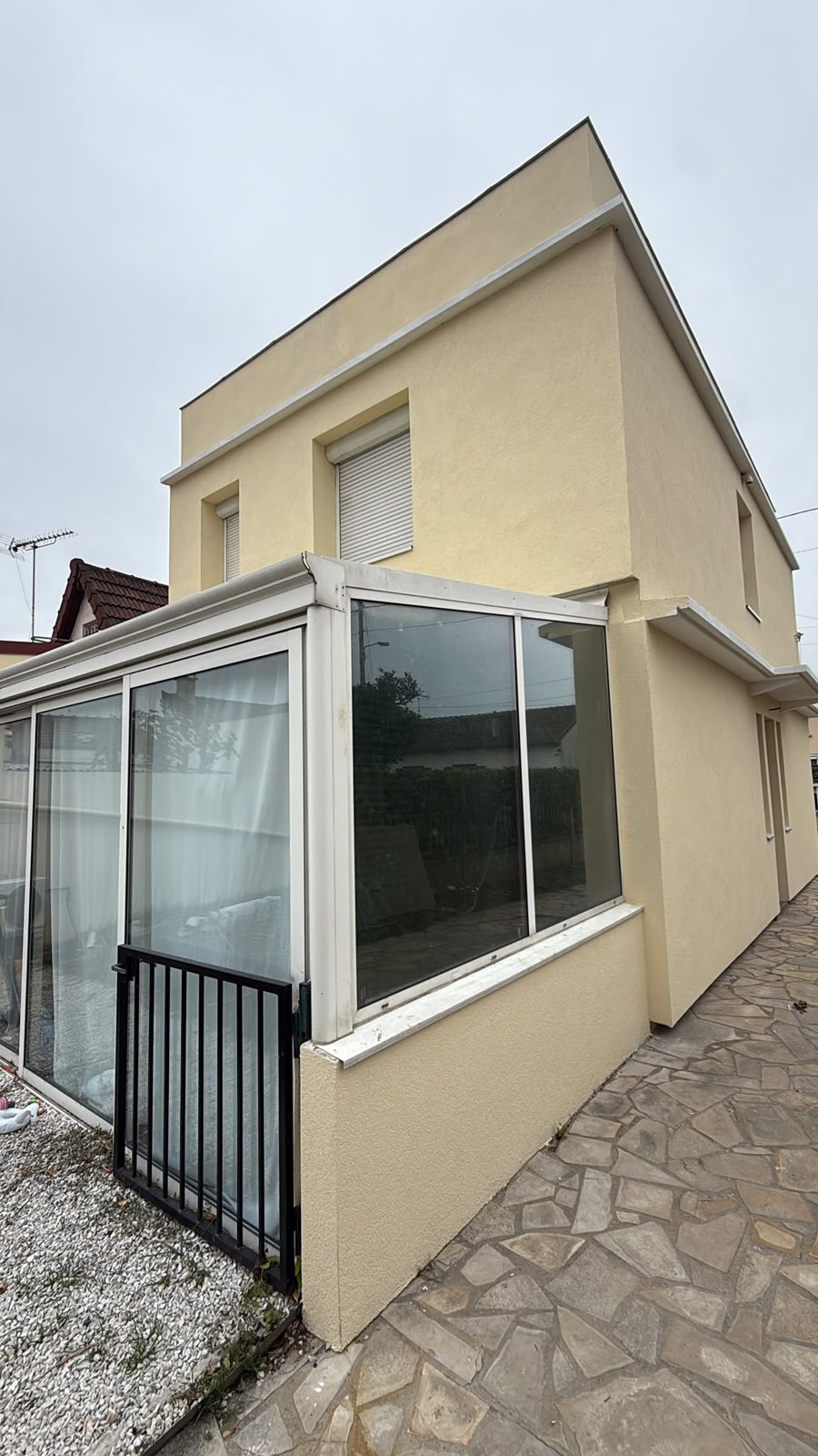 Maison à toit-terrasse à Villeneuve-le-Roi après isolation par l'extérieur, vue d'angle avec la véranda et l'enduit crème
