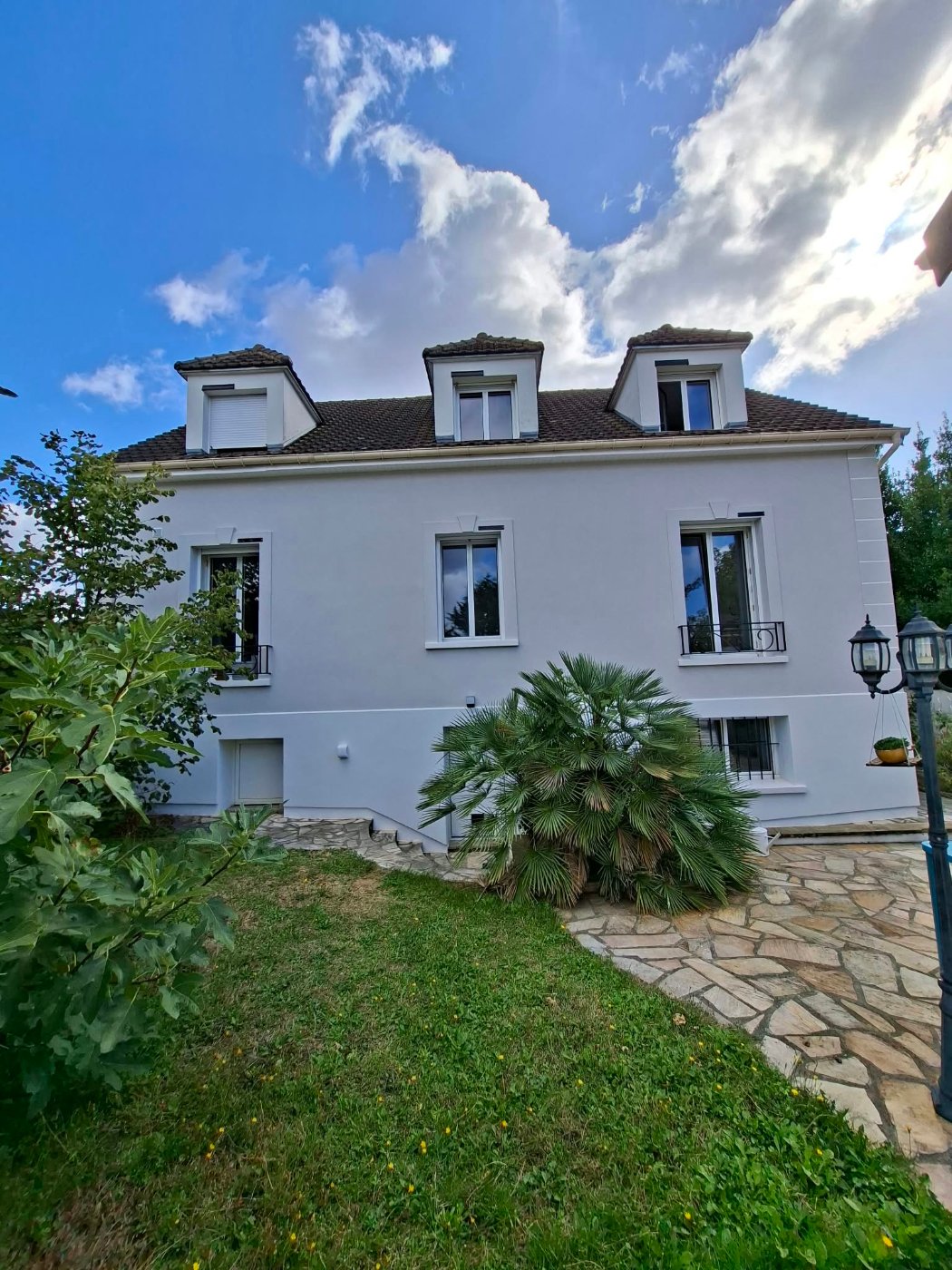 Façade aux trois lucarnes de la maison à Villiers-sur-Marne après ITE, encadrements de fenêtres avec clés reconstitués