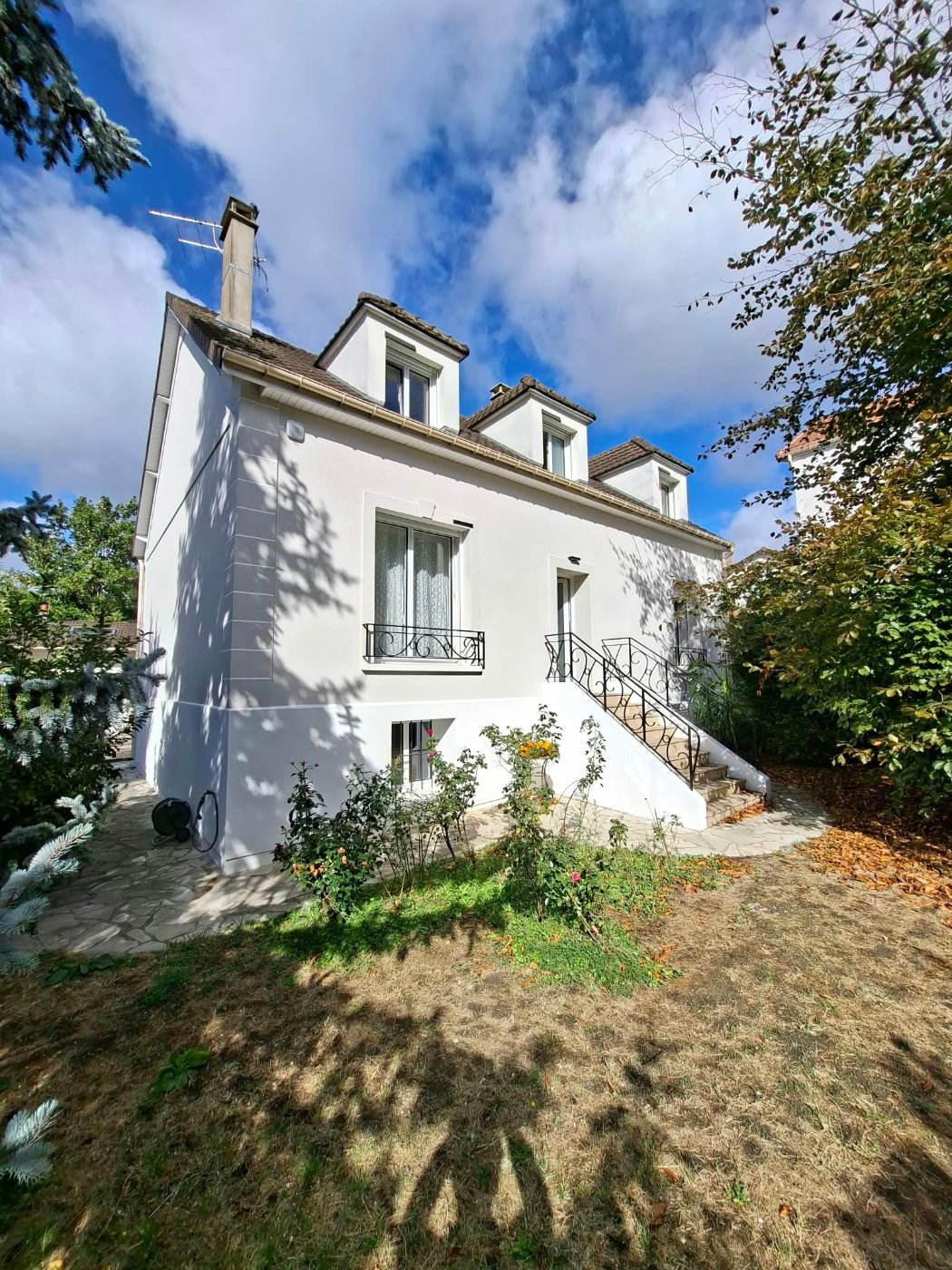 Maison à Villiers-sur-Marne après isolation par l'extérieur : façade blanche, chaîne d'angle, encadrements et perron