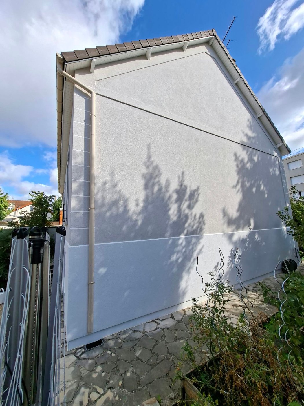 Pignon de la maison à Villiers-sur-Marne après isolation par l'extérieur : enduit neuf, chaîne d'angle et bandeaux reconstitués