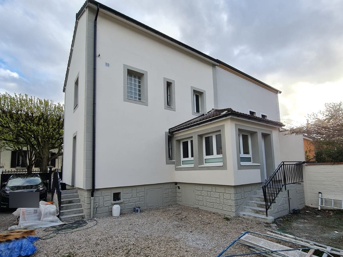 Maison au Perreux-sur-Marne après isolation par l'extérieur, côté jardin : enduit gratté clair et modénatures grises